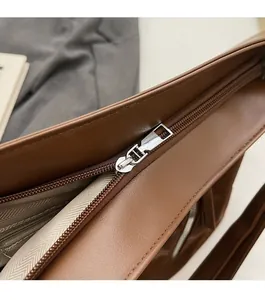 Detail of smooth silver zipper and interior lining of the brown leather tote bag