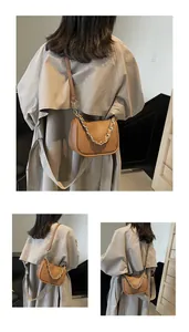 Vue détaillée du sac croissant en cuir marron avec chaîne dorée et bandoulière en cuir