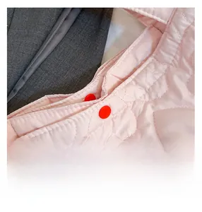 Vista macro del tessuto trapuntato rosa a cuore con doppia chiusura a bottoni automatici