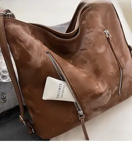 Close-up of caramel brown oil wax leather tote bag with front diagonal zipper pockets
