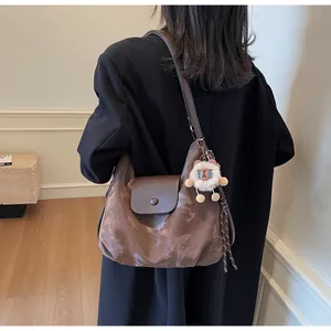 Detail der braun gemusterten Totebag mit Magnetklappe und weichem Plüschtier-Anhänger