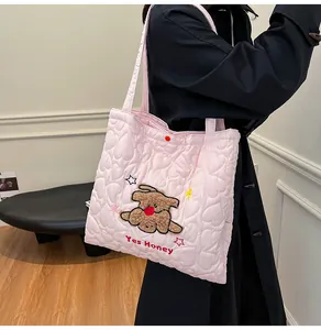 Dettaglio borsa shopper trapuntata rosa con ricamo a cane e motivo a cuori cuciti