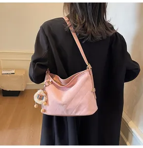 Sac fourre-tout rose matelassé avec pendentif mouton porté à l'épaule par le mannequin