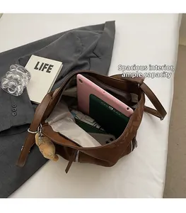 Spacious interior of brown tote bag holding a tablet, notebook, and cute plush charm