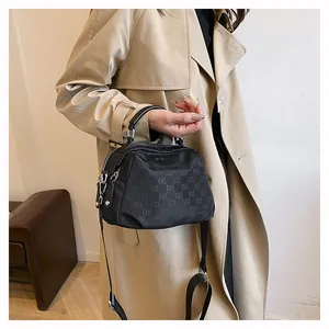 Détail du sac en nylon noir avec logo ELB embossé et fermetures éclair argentées brillantes