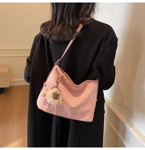 Détail du sac cabas rose matelassé avec charme de lion et logo doré sur le devant