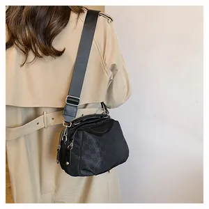 Détail du sac bandoulière en nylon noir avec imprimé monogramme ELB et large bandoulière