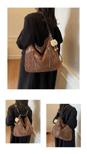 Close-up of caramel brown tote bag with glossy leather texture and twin zippers