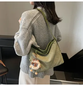 Détail du grand sac cabas matelassé vert avec pendentif en peluche d'agneau