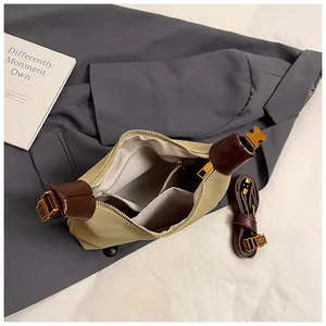 Vista superior del interior del bolso tote beige con compartimentos y ribete de cuero marrón