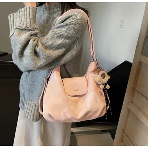Nahaufnahme der rosa Schultertasche mit Marmordruck und Plüschlöwen-Anhänger