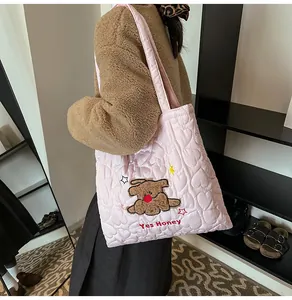 Dettaglio della borsa tote rosa trapuntata con cuciture a cuore e ricamo cucciolo