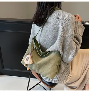 Détail du grand sac cabas matelassé vert olive avec bandoulière et breloque en peluche douce