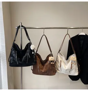 Detailed display of large tote bags in black, brown and white with plush bear charms