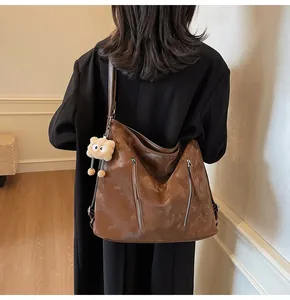 Macro shot of a glossy brown patent leather tote bag with stylish zipper details
