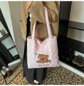 Dettaglio della borsa tote rosa trapuntata con cuori e ricamo di cucciolo di peluche