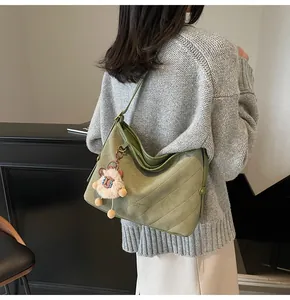Détail du sac hobo matelassé vert texture daim avec pendentif alpaga en peluche
