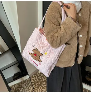 Dettaglio della borsa shopper rosa trapuntata con toppa orsetto e stelle ricamate
