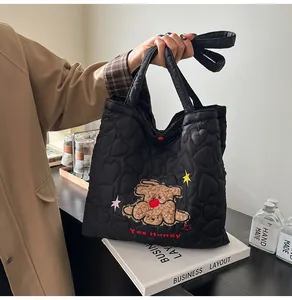 Dettaglio borsa shopper nera trapuntata con ricamo di cagnolino e testo Yes Honey