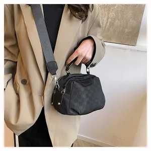Détail du sac bandoulière en nylon noir avec logo jacquard et large bandoulière