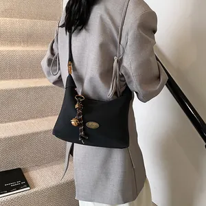 Bolso vintage negro de hombro con colgante de campana dorada y placa de metal