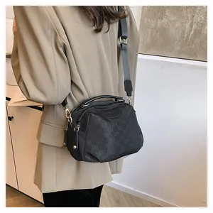 Détail du sac bandoulière en nylon noir avec motif jacquard ELB et sangle large