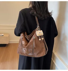 Detail view of brown tote bag with marble texture and cute plush bear accessory