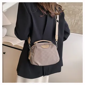 Détail du sac bandoulière en nylon avec logo gaufré et large bandoulière tissée