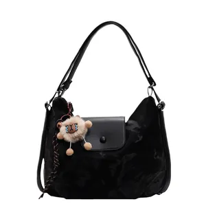 Große schwarze Tragetasche mit Lederklappe und süßem Löwen-Plüschtier auf weißem Grund