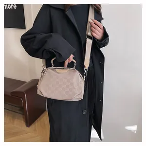 Vue latérale d'un sac bandoulière en nylon beige avec monogramme et large sangle