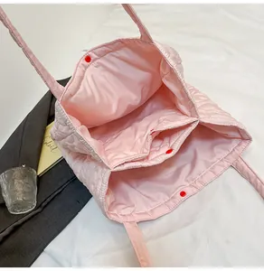 Vista interna della borsa tote trapuntata rosa con scomparti multipli e bottoni a pressione