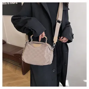 Détail du sac bandoulière en nylon avec motif jacquard ELB et large bandoulière tissée