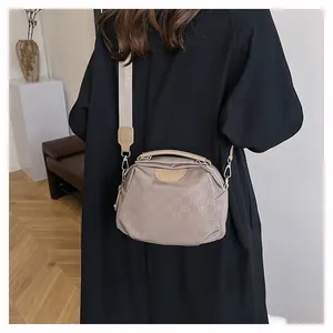 Détail du sac bandoulière en nylon taupe avec imprimé monogramme EB et large bandoulière