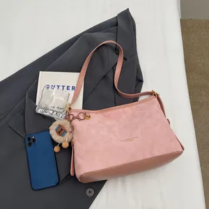 Sac fourre-tout matelassé rose avec un ours en peluche marron sur une veste grise