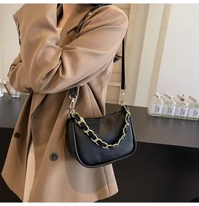 Détail du sac bandoulière en cuir noir grainé avec chaîne dorée et fine bandoulière