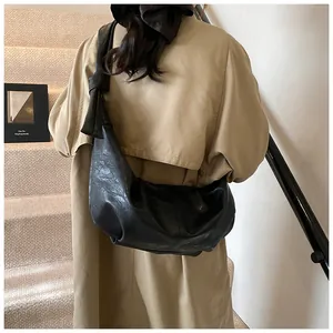 Detail of the oversized black hobo bag with a distinctive knot on the shoulder strap