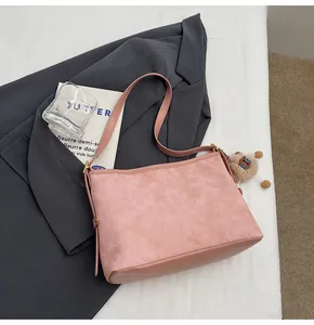 Sac fourre-tout rose en daim matelassé avec pendentif ours sur veste de blazer grise