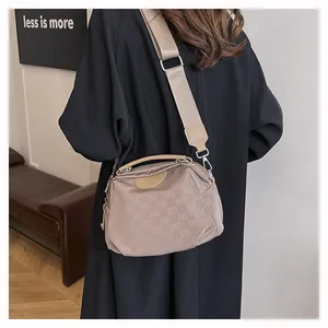 Détail du sac bandoulière beige en nylon avec motif ELB et large sangle en tissu