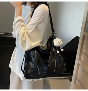 Detail of glossy black tote bag with luxury texture and cute white cloud pendant