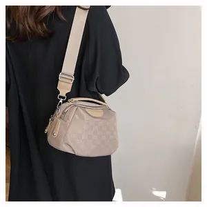 Détail du sac à bandoulière en nylon kaki avec imprimé lettres et large sangle en tissu