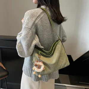Sac fourre-tout matelassé vert avec charm mouton porté par un mannequin en intérieur