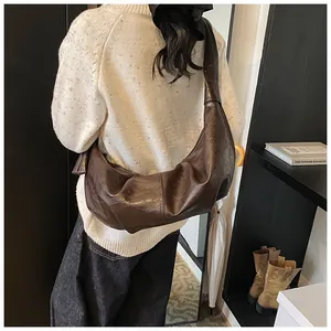 Macro detail of dark brown hobo bag with vintage textured leather and knotted shoulder strap