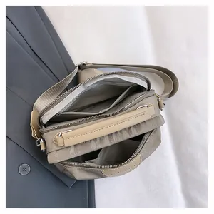 Vue détaillée du dessus montrant les trois compartiments zippés du sac en nylon