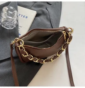Détail de l'intérieur du sac à main marron avec poche zippée et chaîne dorée élégante