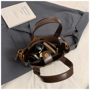 Detailed interior view of a deep brown bucket bag showing magnetic closure and inner pocket