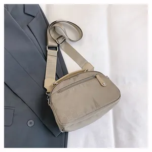Détail du sac bandoulière en nylon kaki avec imprimé ELB et large sangle réglable