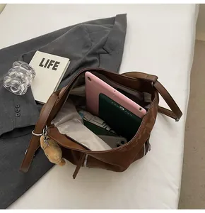 Top view of spacious brown bucket bag interior with a cute bear charm accessory