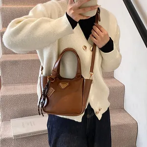 Brown leather bucket bag for women with top handles and adjustable crossbody strap
