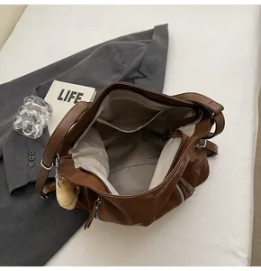 Detail of brown tote bag interior with multiple pockets and a cute plush bear charm