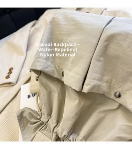 Detail of water-repellent nylon fabric on beige drawstring backpack with metal hardware
